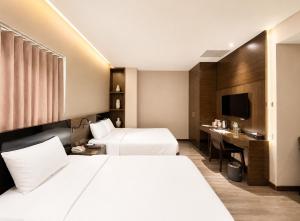 a hotel room with two beds and a desk at Queen Ann Hotel in Ho Chi Minh City +59 photos