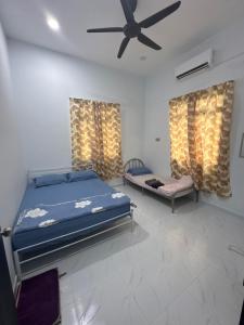 a bedroom with two beds and a ceiling fan at HomestayDino in Kuala Terengganu