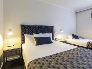 a hotel room with two beds and two lamps at Mercure Albury in Albury +120 photos