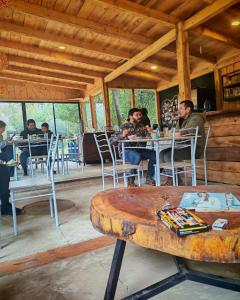 a group of people sitting at tables in a restaurant at Glamp Refugio Silvestre 7 Tazas in Molina
