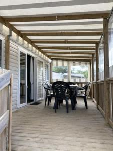 a patio with chairs and a table on a porch at MysavinaHouse mobilhome 4 à 6 pers camping 4 Etoiles in Piriac-sur-Mer
