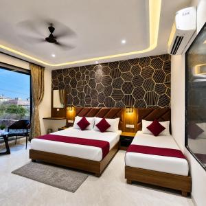 two beds in a hotel room with at Hotel Aroma in Mathura