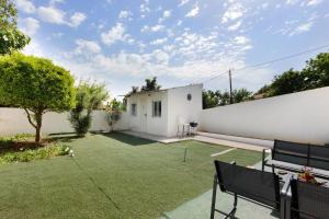 a backyard with a white wall and two benches at Manuel'shouse in Vila Nova de Gaia