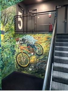 a bike painted on the side of a building with stairs at Big Lodge in Peebles +8 photos