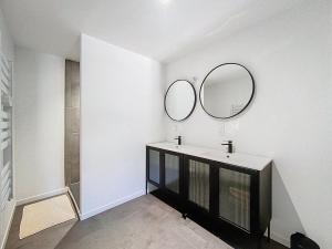 a bathroom with a sink and two mirrors on the wall at Appartement 4 personnes in Cholet
