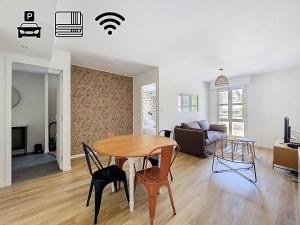 a living room with a table and chairs and a couch at Appartement 4 personnes in Cholet