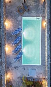 an overhead view of a swimming pool with two umbrellas at Dreamy Charaki 2 Bd Villa with Private Pool in Haraki