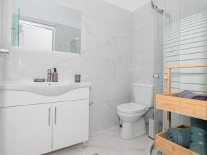a white bathroom with a sink and a toilet at Dreamy Charaki 2 Bd Villa with Private Pool in Haraki