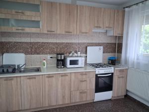 a kitchen with wooden cabinets and a white stove top oven at Casa Corina in Turda
