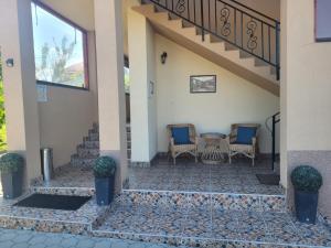 a patio with chairs and a table and a staircase at Casa Corina in Turda