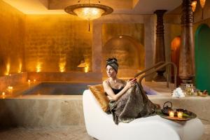 a woman sitting in a chair in a bath tub at Hotel Metropole Venezia in Venice
