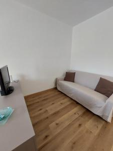 a white couch in a room with a wooden floor at Il Lago di Luciana in Intra