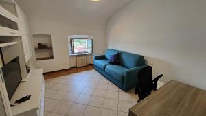 a living room with a blue couch and a table at Casa Manola in Le Grazie