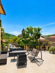 eine Terrasse mit Tischtennisplatte und Schaukel in der Unterkunft Hotel Prime in Mzcheta