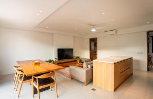 a living room with a wooden table and a couch at CASA MIA - Luxury Apartments Central Kuta in Kuta Lombok