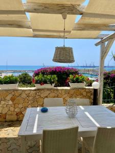 a white table and chairs on a patio with flowers at Casa Mare Holiday Pozzallo in Pozzallo