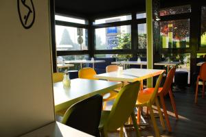a restaurant with tables and chairs and a window at ibis budget Saint-Omer Centre in Saint-Omer