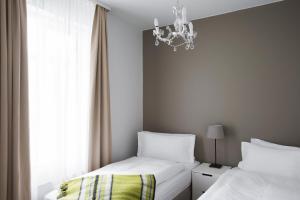 ein Schlafzimmer mit zwei Betten und einem Kronleuchter in der Unterkunft Hotel Ódinsvé in Reykjavík + 150 Fotos