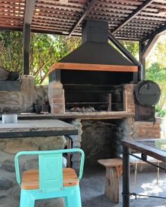 an outdoor oven with a table and a bench at Glamp Refugio Silvestre 7 Tazas in Molina