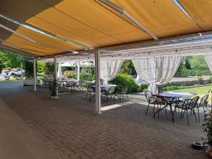 a group of tables and chairs under acovered patio at Agriturismo Papaveri & Papere in Caltana