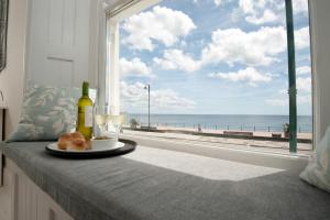 a table with a plate of food and a window with a view of the beach at Sophia's in Penzance