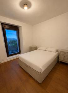a bedroom with a large bed and a window at Jaca Stone in Banaguás