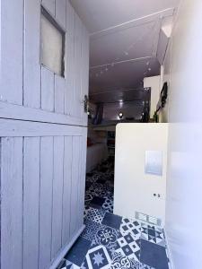 a room with a door and a tiled floor at Solar Powered Hideaway converted horse box in Fishbourne +16 photos