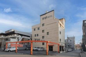 a building with cars parked in a parking lot at No25 Hotel Chuncheon Cityhall in Chuncheon