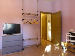 ピサにあるElisir b&bのテレビ、ドレッサー、クローゼットが備わる客室です。