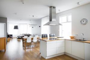 eine Küche und ein Esszimmer mit weißen Schränken und einem Tisch in der Unterkunft Hotel Ódinsvé in Reykjavík