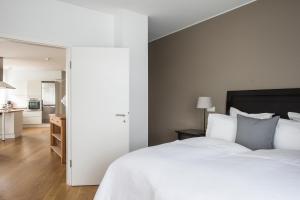 ein Schlafzimmer mit einem großen weißen Bett und eine Küche in der Unterkunft Hotel Ódinsvé in Reykjavík