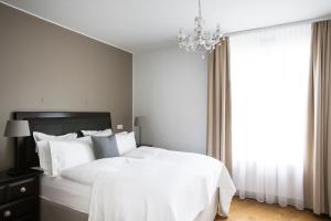 ein Schlafzimmer mit einem weißen Bett und einem Kronleuchter in der Unterkunft Hotel Ódinsvé in Reykjavík