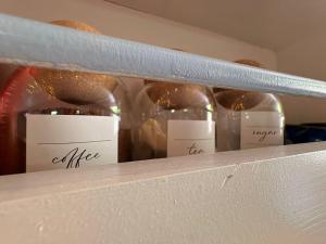 three bottles of wine sitting on a shelf at Solar Powered Hideaway converted horse box in Fishbourne