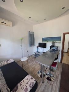 a room with a bed and a desk with a table at Brane Apartmani in Zadar