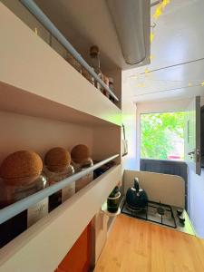 a kitchen with a stove and some breads on shelves at Solar Powered Hideaway converted horse box in Fishbourne