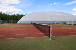 a tennis court with a domed building in the background at Tanhuvaaran urheiluopisto & Sport Resort in Savonlinna