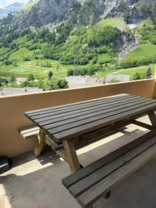 a wooden picnic table on a balcony with a view of a mountain at Eldorado 47 grosse Wohnung mit Wunderschönen Aussicht in Leukerbad +1 photo