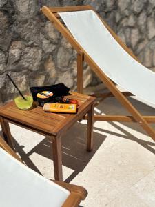 a wooden table next to a chair with a drink on it at Solmare Neum Apartmani in Neum