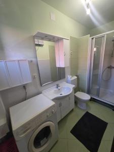 a bathroom with a washing machine and a sink at Brane Apartmani in Zadar