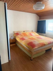 a bedroom with a bed with a colorful comforter at Eldorado 47 grosse Wohnung mit Wunderschönen Aussicht in Leukerbad