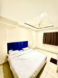 a large bed with a blue headboard in a bedroom at Hotel Durga Palace in Ujjain