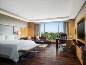 a hotel room with a large bed and a television at JW Marriott Hotel Chandigarh in Chandīgarh