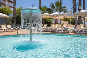 a fountain in a pool with chairs and umbrellas at htop Jadhe SPA 4Sup - Bliss in Calella