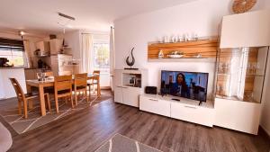 a living room with a television and a dining room at Friesenhaus Düwels Hus in Greetsiel