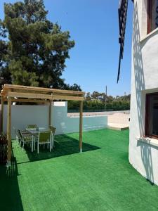 a patio with a table and chairs on green grass at El Molino de Valverde in Elche