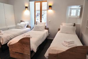 two beds in a room with towels on them at Le Passage - Gîte 2 à 15 personnes Chartreuse terrasse, calme & nature in Saint-Pierre-dʼEntremont