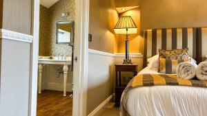 a bedroom with a bed and a sink and a lamp at Bettws Hall Accommodation in Newtown +46 photos