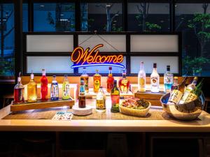 a bar with bottles of alcohol and a bowl of food at Super Hotel Akihabara Suehirocho in Tokyo
