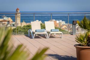two white chairs sitting on a balcony with a view at htop Jadhe SPA 4Sup - Bliss in Calella