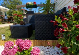 a garden with pink flowers and a fence at Casa Nature's Avlis Bungalow 4XZ in Pataias